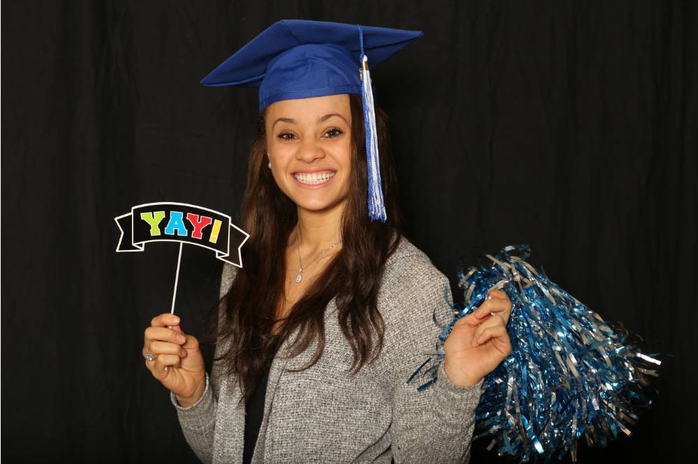 soon to be graduate takes a fun picture with photobooth props